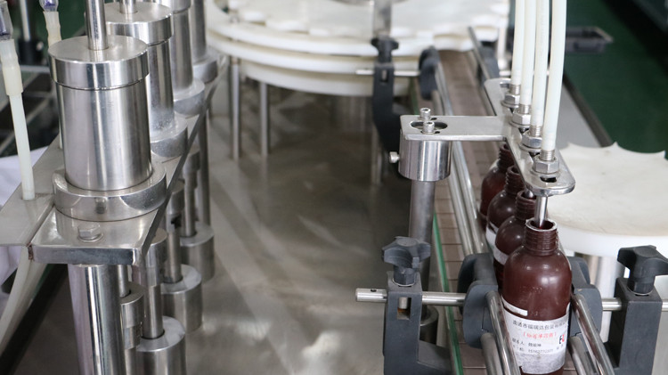 કેપ સીલિંગ અને સ્ટાર વ્હીલ દોડવા સાથે 500 મિલી રાઉન્ડ બોટલ ભરવાનું મશીન